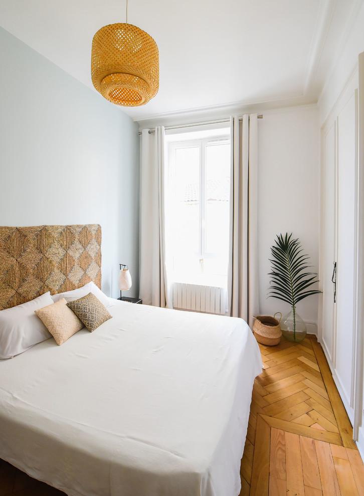 リヨンにある小さなトロピカルスタイルのおしゃれな主寝室 (淡色無垢フローリング、青い壁、ベージュの床) のインテリア
