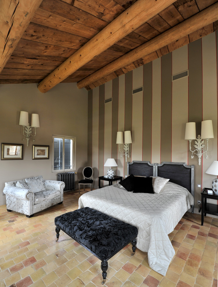 Immagine di una grande camera matrimoniale tradizionale con pareti beige e pavimento in terracotta