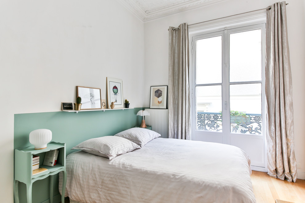 Idées déco pour une chambre parentale haussmannienne classique de taille moyenne avec parquet clair et un mur vert.