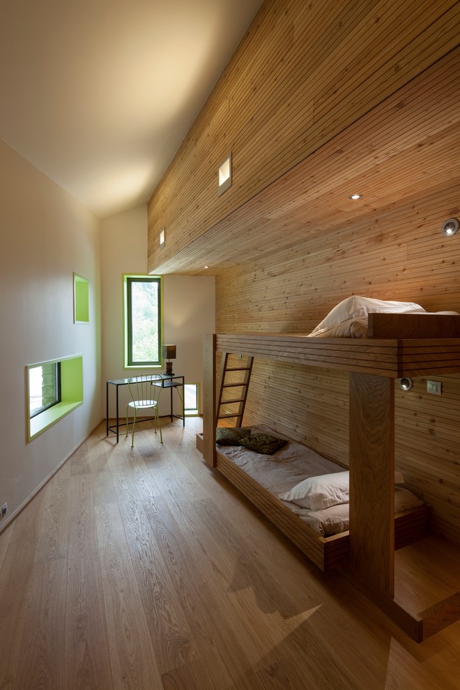 Exemple d'une chambre d'amis montagne de taille moyenne avec un sol en bois brun et un mur blanc.