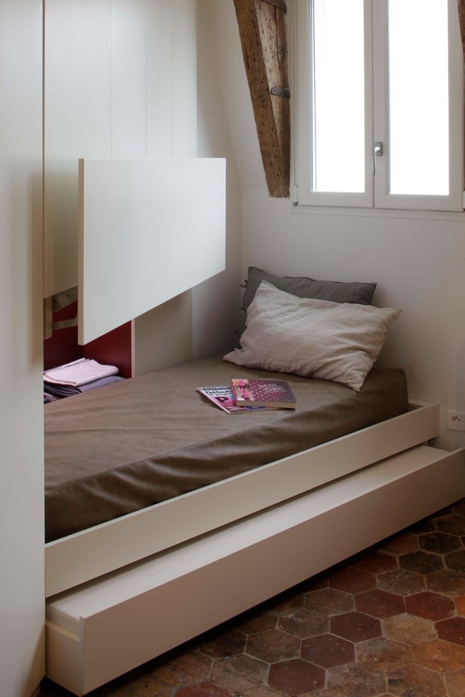Ejemplo de habitación de invitados actual pequeña con suelo de baldosas de terracota