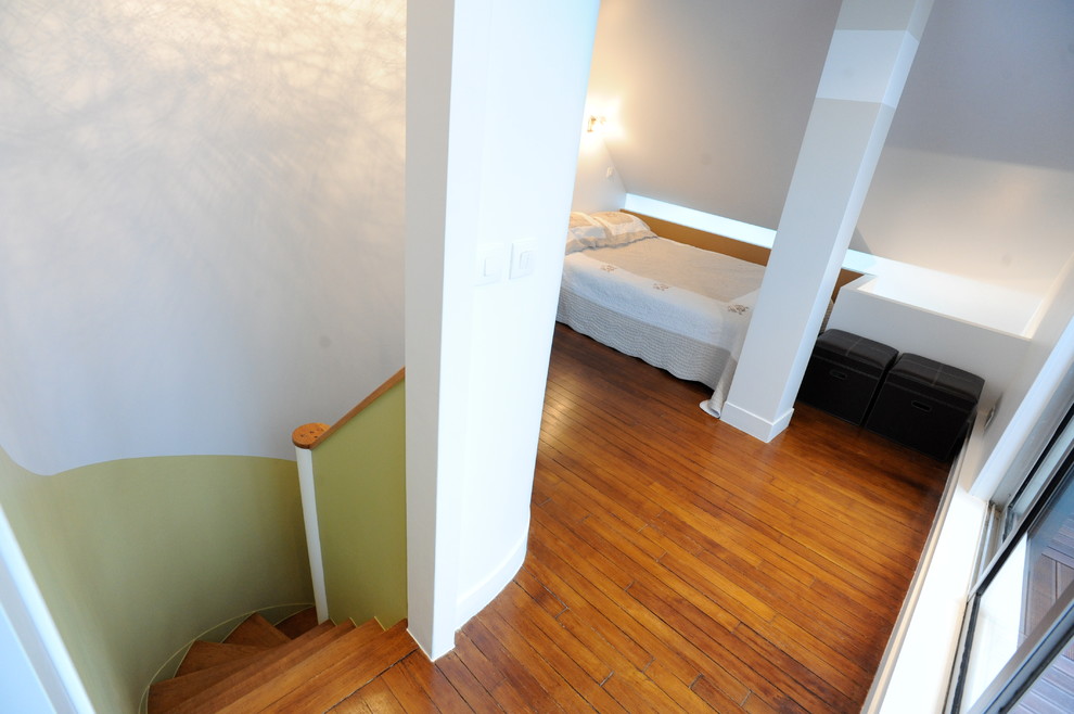 Immagine di una piccola camera da letto stile loft boho chic con pareti beige, pavimento in legno massello medio e nessun camino