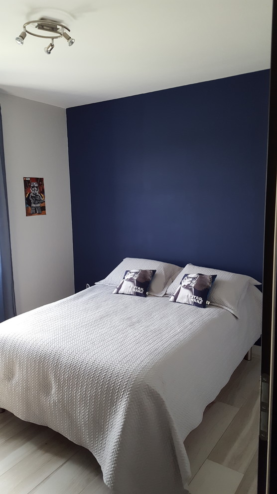 Aménagement d'une petite chambre d'amis moderne avec un mur bleu, parquet peint et un sol gris.