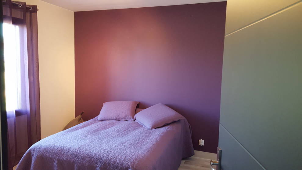 Cette image montre une petite chambre d'amis minimaliste avec un mur violet, parquet peint et un sol gris.