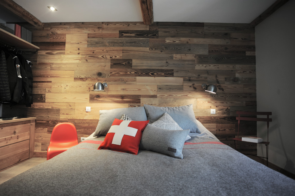 Uriges Schlafzimmer mit weißer Wandfarbe, braunem Holzboden und grauem Boden in Grenoble