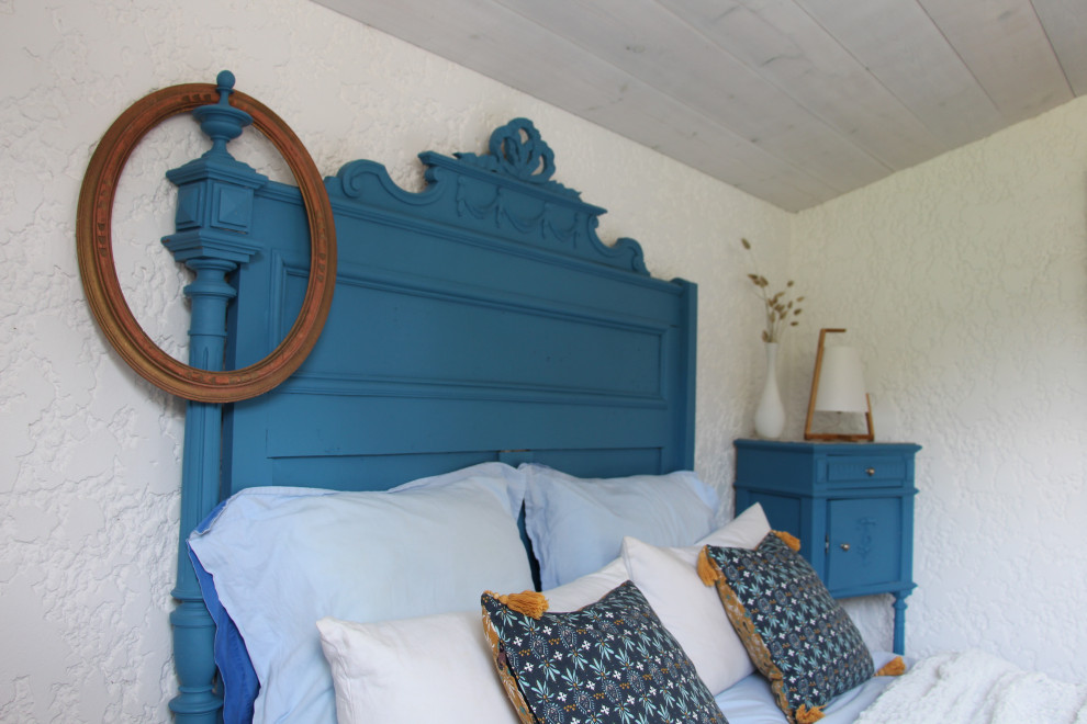 Ispirazione per una camera da letto costiera di medie dimensioni con pareti bianche, pavimento in laminato, pavimento grigio e soffitto in legno