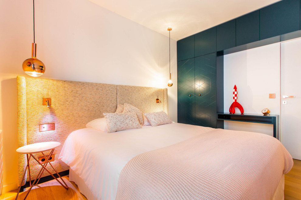 На фото: гостевая спальня среднего размера, (комната для гостей) в современном стиле с белыми стенами, светлым паркетным полом и бежевым полом без камина с