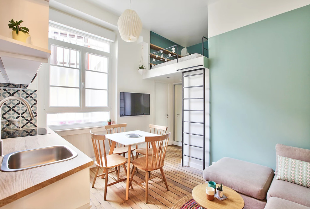 Aménagement d'une petite chambre mansardée ou avec mezzanine scandinave avec un sol en bois brun, un mur bleu et un sol marron.