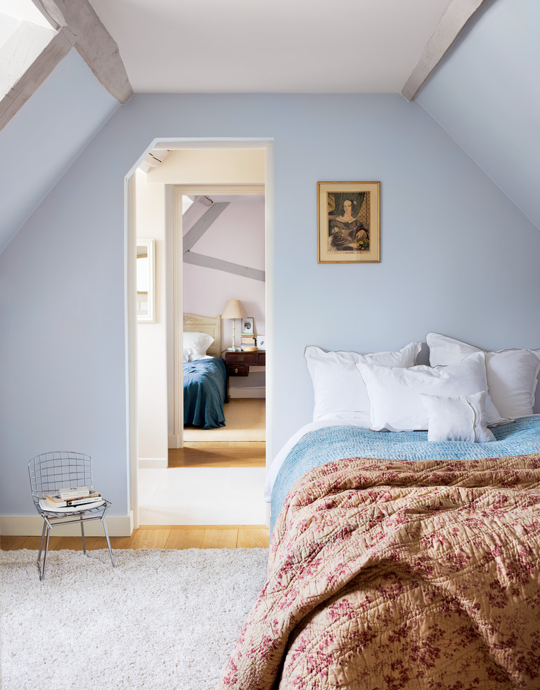 Foto de habitación de invitados campestre de tamaño medio con paredes azules, suelo de madera en tonos medios y techo inclinado