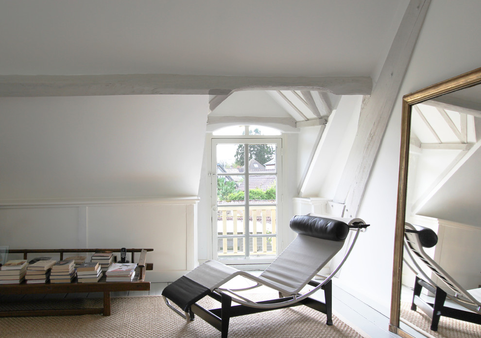 This is an example of a midcentury loft bedroom in Paris with white walls.