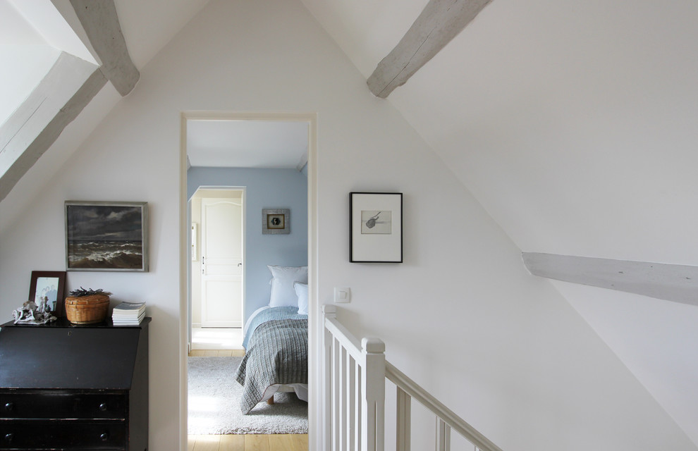 Inspiration pour une chambre parentale rustique de taille moyenne avec un mur bleu et parquet clair.