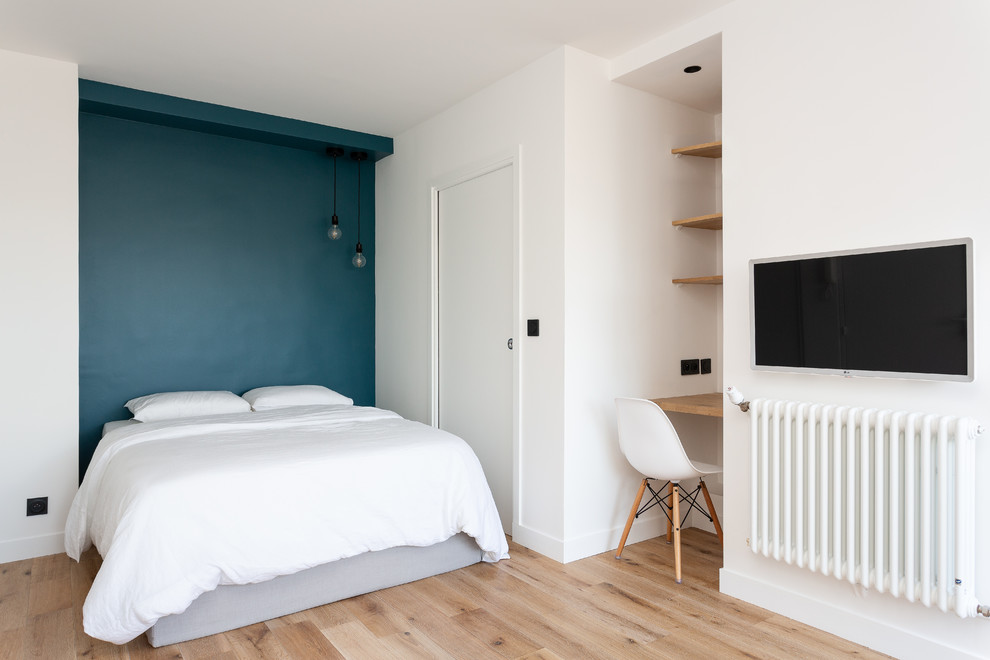 Diseño de dormitorio principal escandinavo grande sin chimenea con paredes blancas, suelo de madera en tonos medios y suelo beige
