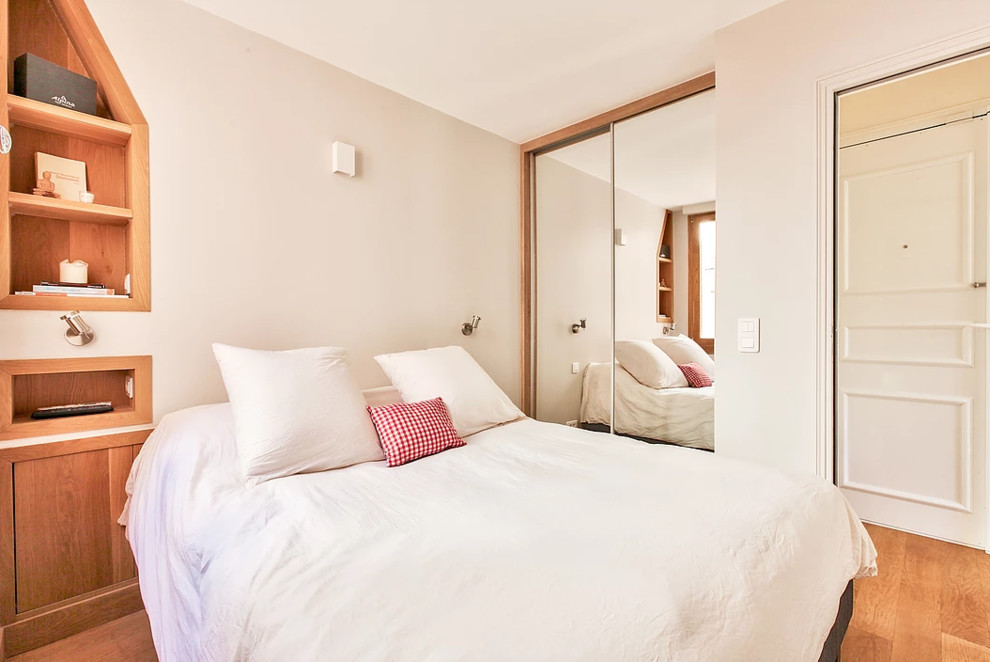 Medium sized classic master bedroom in Paris with beige walls, medium hardwood flooring, no fireplace and brown floors.