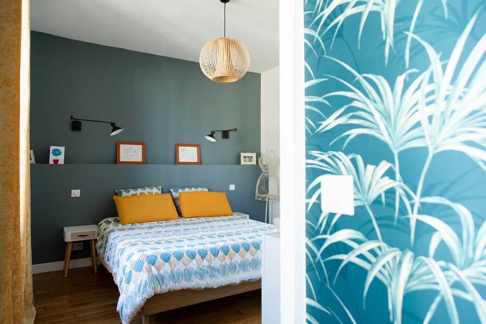 Exemple d'une chambre parentale moderne de taille moyenne avec un mur bleu, un sol en bois brun, aucune cheminée, un sol marron et du papier peint.