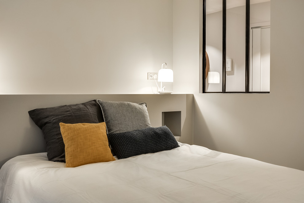 Ejemplo de dormitorio principal contemporáneo de tamaño medio sin chimenea con paredes grises y suelo de madera clara