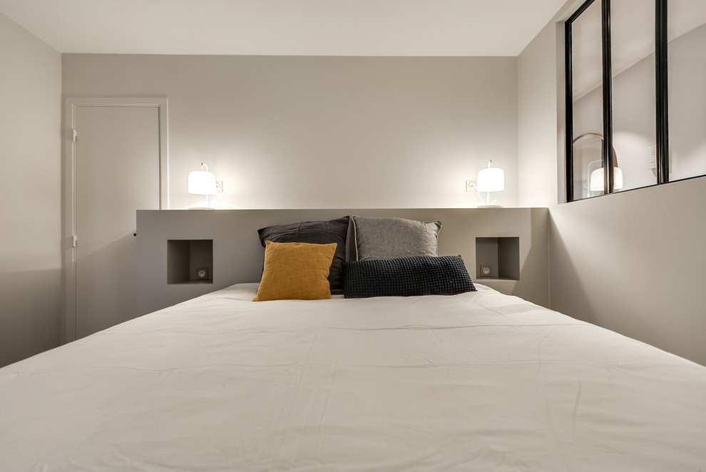 Mittelgroßes Modernes Hauptschlafzimmer ohne Kamin mit weißer Wandfarbe und hellem Holzboden in Paris