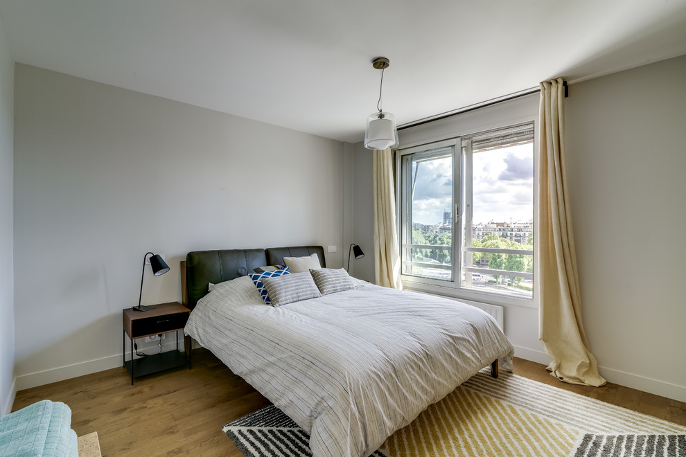 Mittelgroßes Modernes Hauptschlafzimmer ohne Kamin mit beiger Wandfarbe und hellem Holzboden in Paris