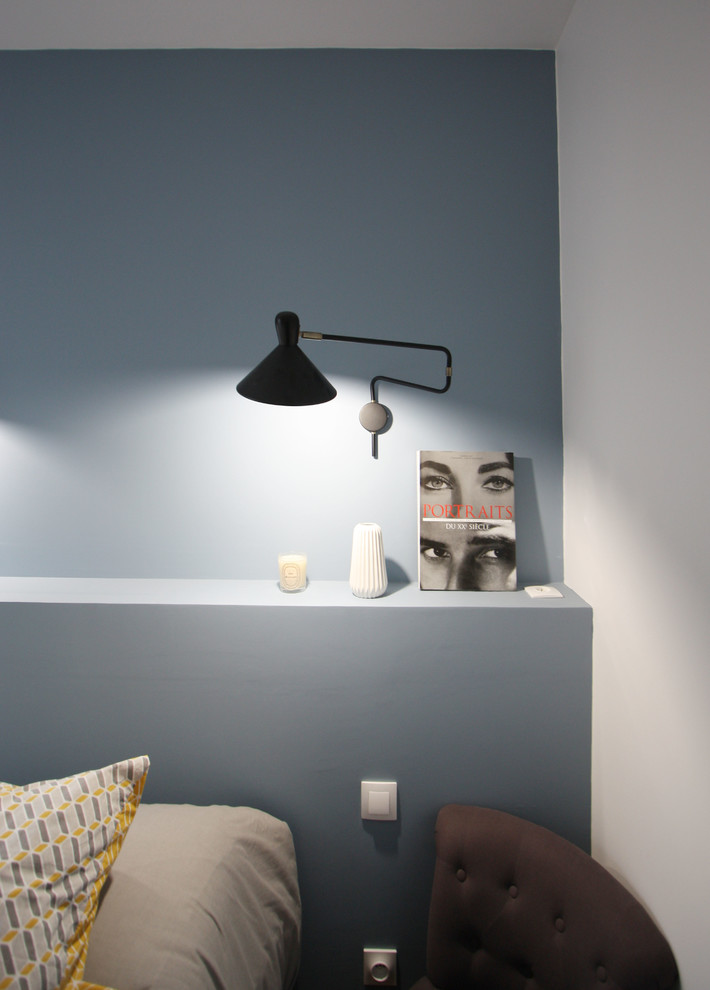 Immagine di una camera da letto scandinava con pareti blu e pavimento in legno massello medio