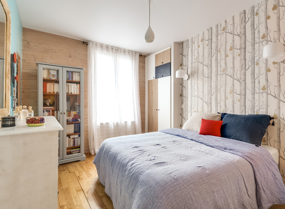Ejemplo de dormitorio principal nórdico sin chimenea con suelo de madera clara y paredes multicolor