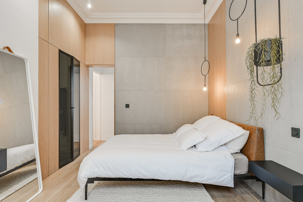 This is an example of a medium sized scandinavian master bedroom in Paris with grey walls, light hardwood flooring and no fireplace.