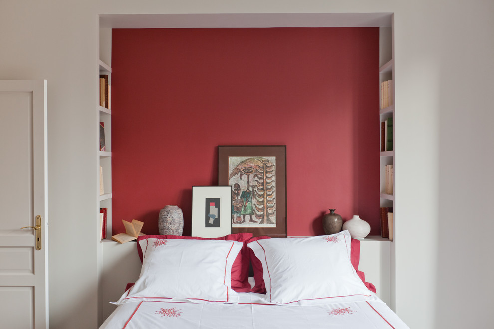 Small world-inspired guest bedroom in Paris with red walls and a feature wall.