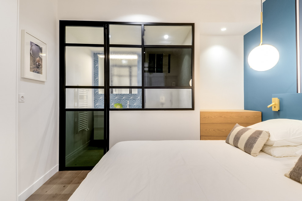 Bedroom - mid-sized scandinavian master dark wood floor and brown floor bedroom idea in Paris with blue walls