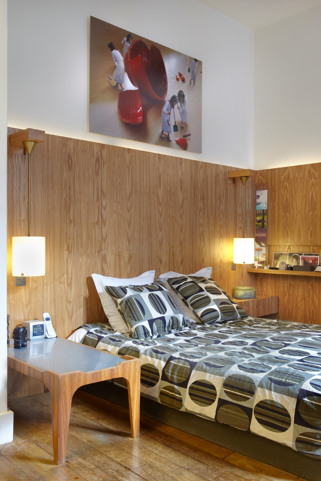Cette photo montre une chambre parentale tendance avec un sol en bois brun.