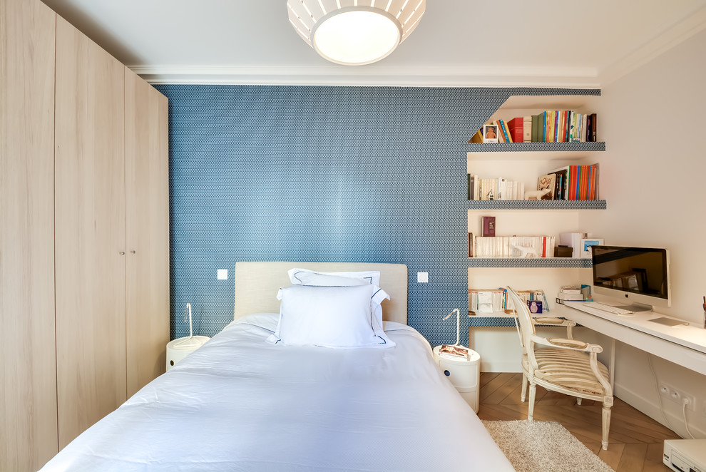 Photo of a scandi bedroom in Paris with blue walls and light hardwood flooring.