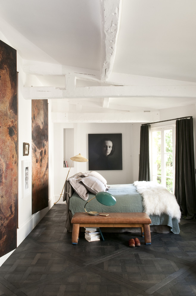 Eklektisk inredning av ett sovrum, med vita väggar, mörkt trägolv och svart golv
