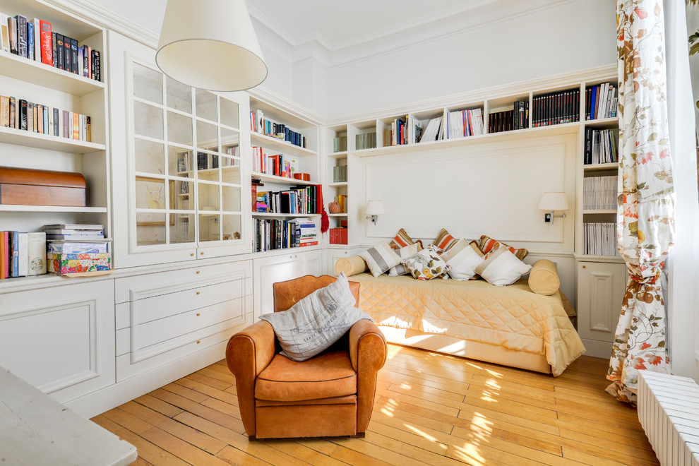 Cette image montre une chambre d'amis design de taille moyenne avec un mur blanc, parquet clair, aucune cheminée et un sol beige.