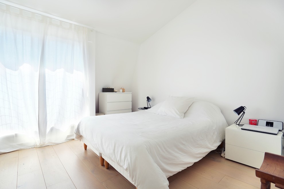 Inspiration pour une chambre nordique de taille moyenne avec un mur blanc et parquet clair.