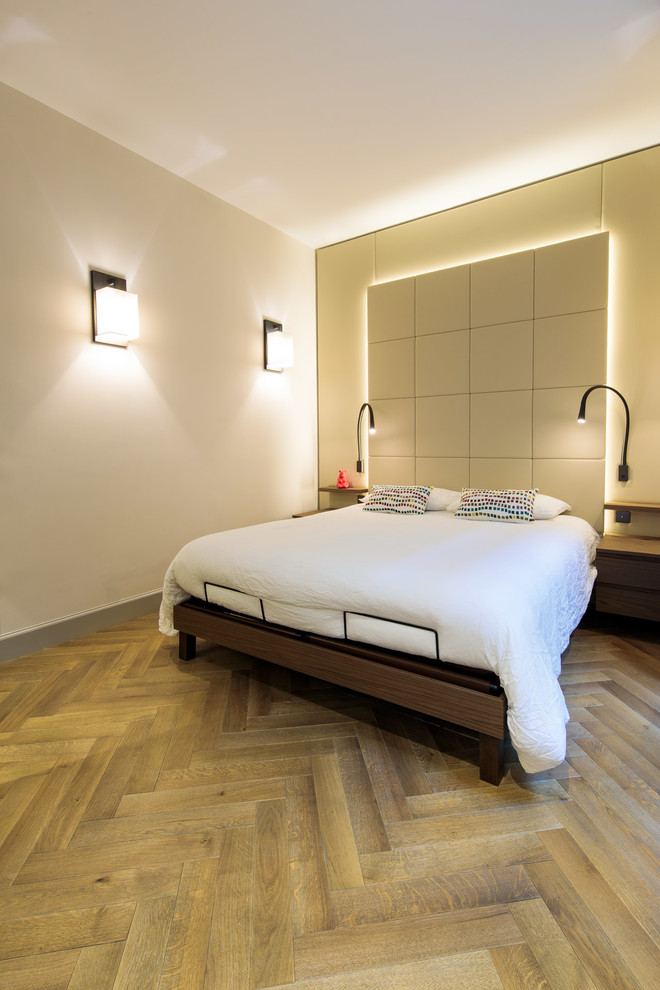 Idée de décoration pour une chambre d'amis design de taille moyenne avec un mur beige et parquet clair.