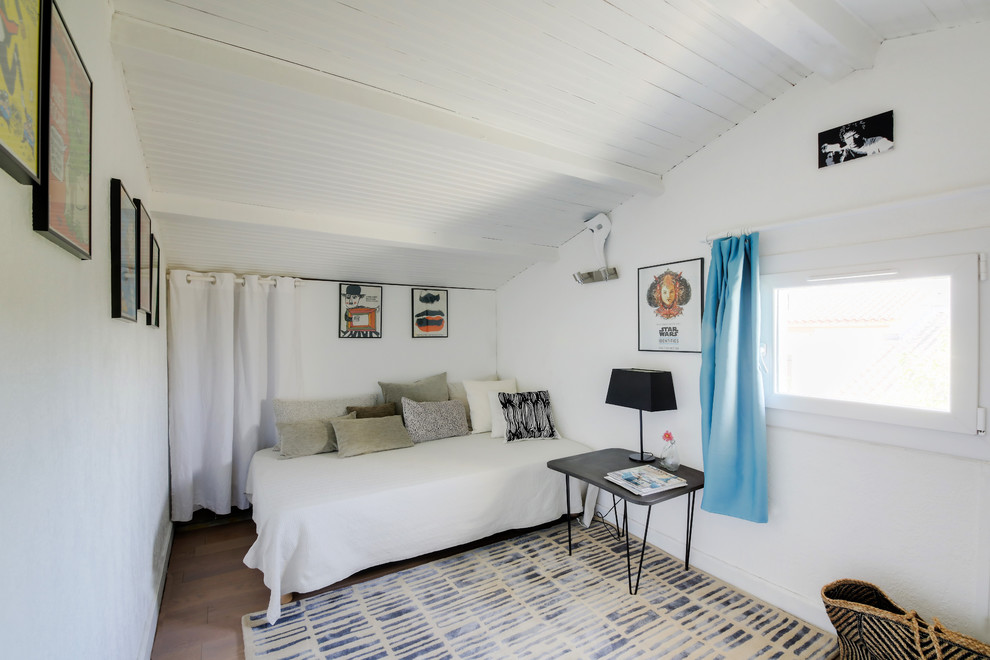 Modelo de dormitorio tipo loft nórdico pequeño sin chimenea con paredes blancas, suelo de madera en tonos medios y suelo marrón
