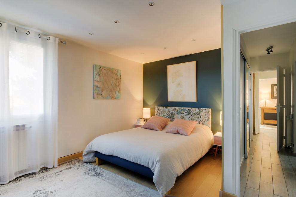 Idée de décoration pour une chambre parentale minimaliste de taille moyenne avec un mur vert, parquet clair, aucune cheminée et un sol beige.