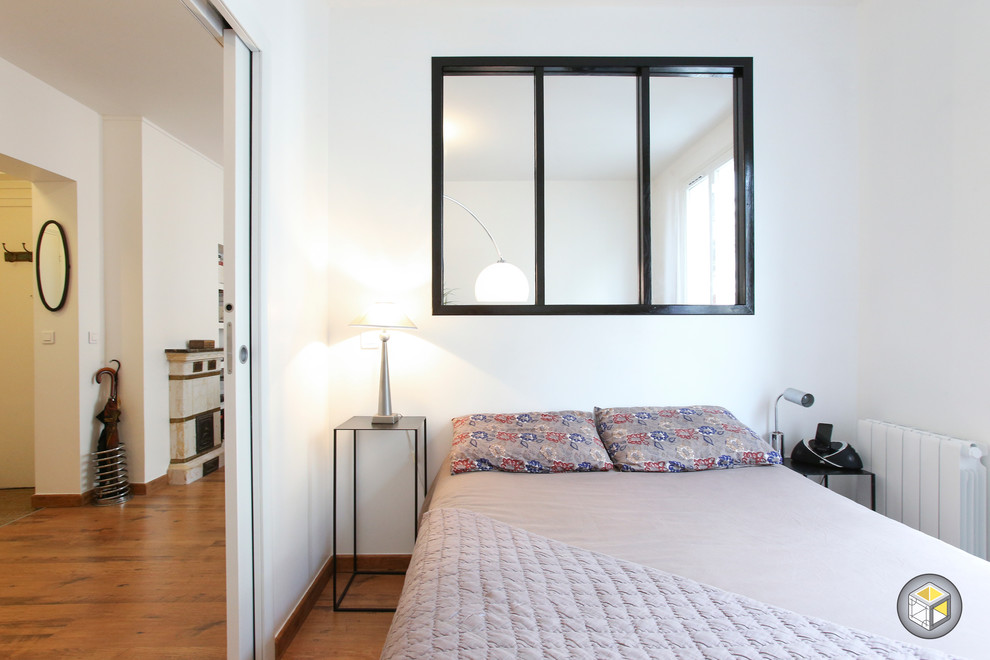 Kleines Modernes Hauptschlafzimmer ohne Kamin mit weißer Wandfarbe und braunem Holzboden in Paris