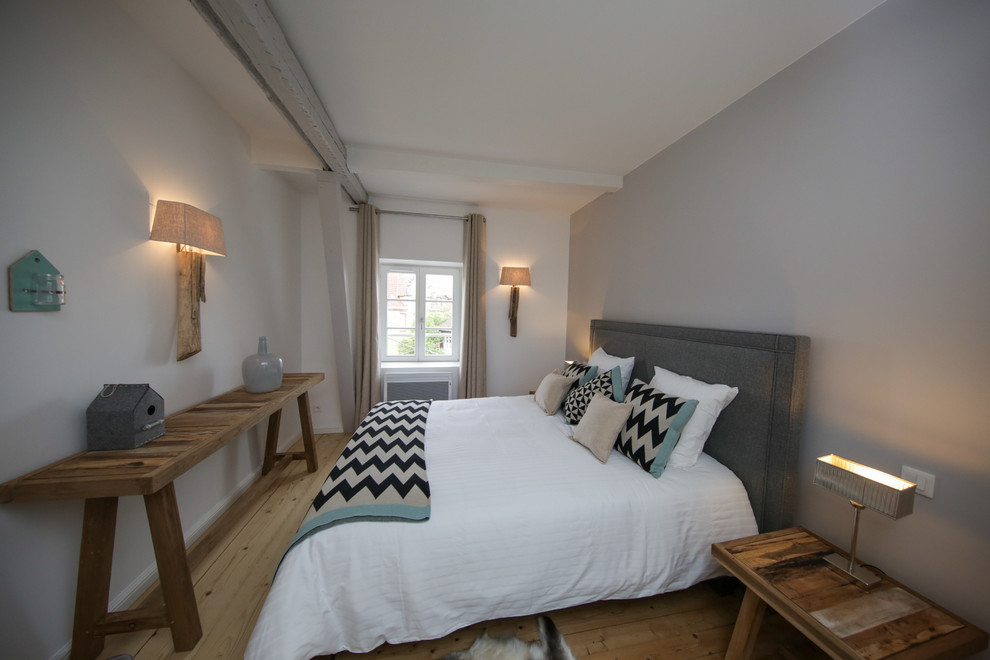 Kleines Modernes Hauptschlafzimmer ohne Kamin mit grauer Wandfarbe und hellem Holzboden in Straßburg
