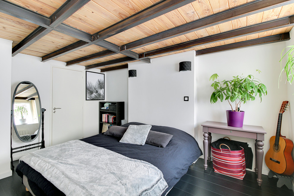 Источник вдохновения для домашнего уюта: спальня в современном стиле с белыми стенами, черным полом, балками на потолке и деревянным потолком