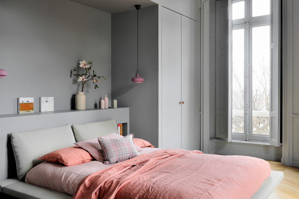 На фото: хозяйская спальня среднего размера в современном стиле с серыми стенами, светлым паркетным полом, стандартным камином и бежевым полом с