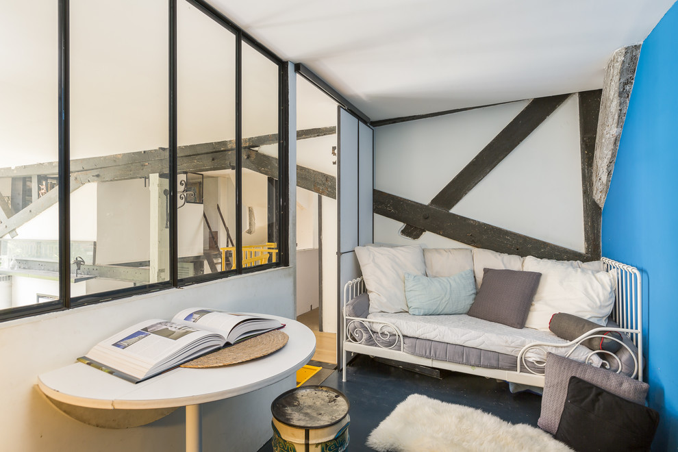 Diseño de dormitorio tipo loft urbano sin chimenea con paredes azules y suelo negro