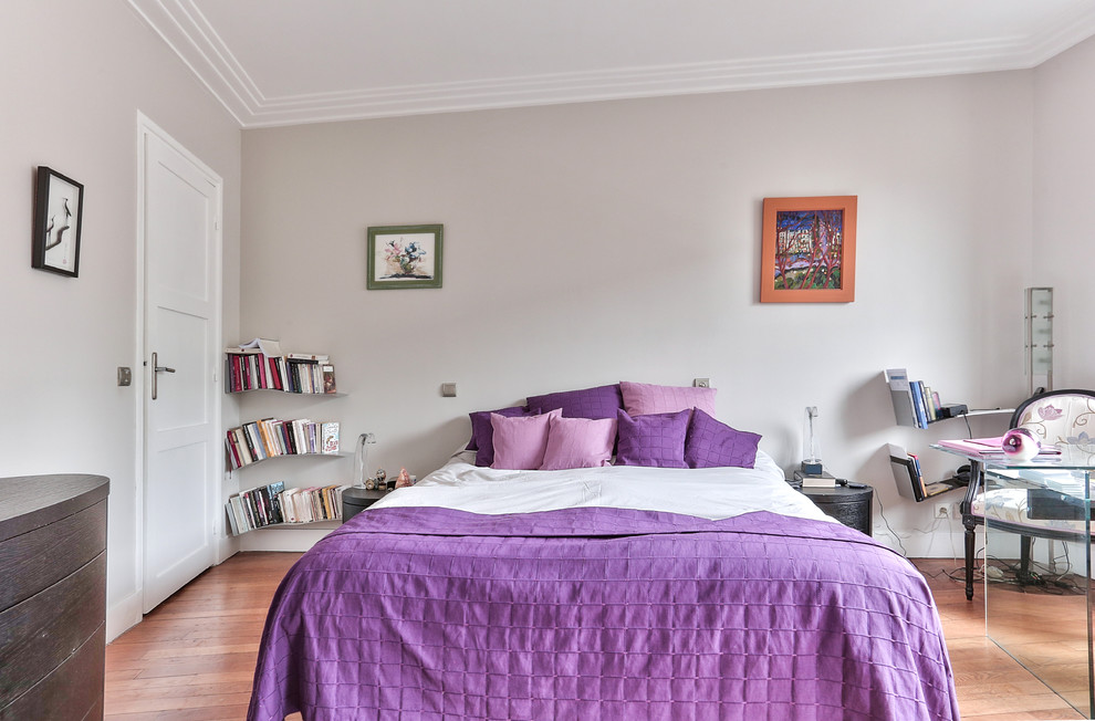 Diseño de dormitorio principal moderno de tamaño medio con paredes grises y suelo de madera en tonos medios