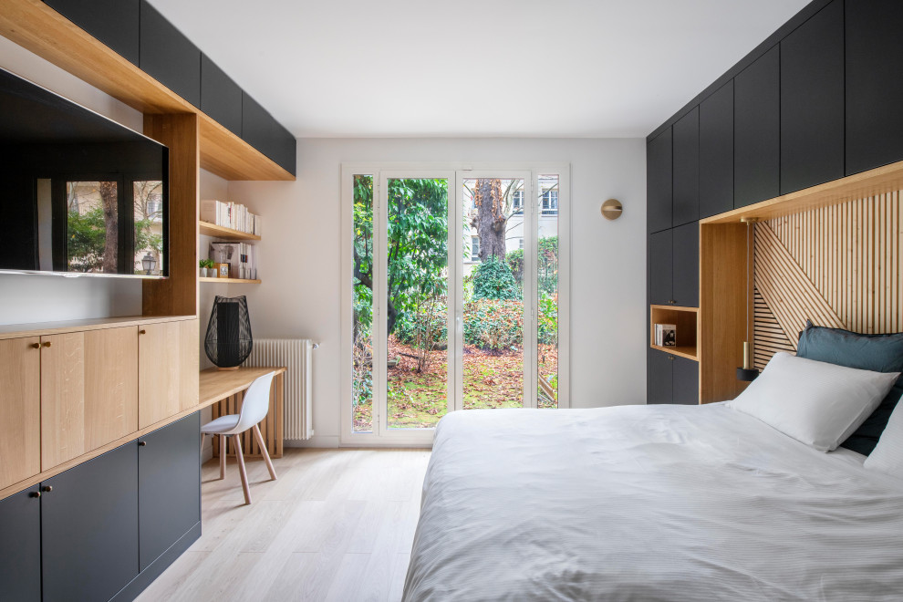 Modelo de dormitorio contemporáneo con paredes blancas, suelo de madera clara y suelo beige