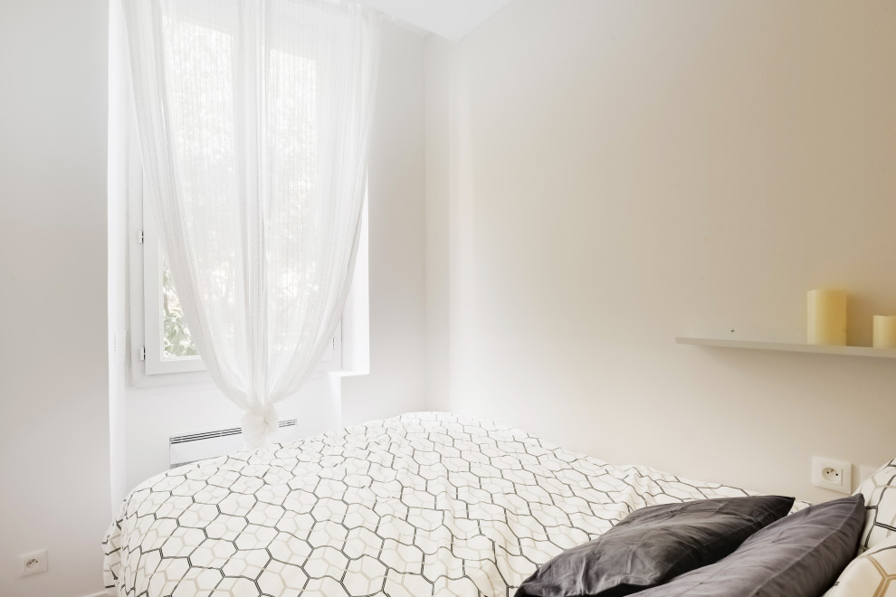 Esempio di una piccola camera da letto nordica con pareti beige, pavimento in laminato, pavimento marrone e boiserie