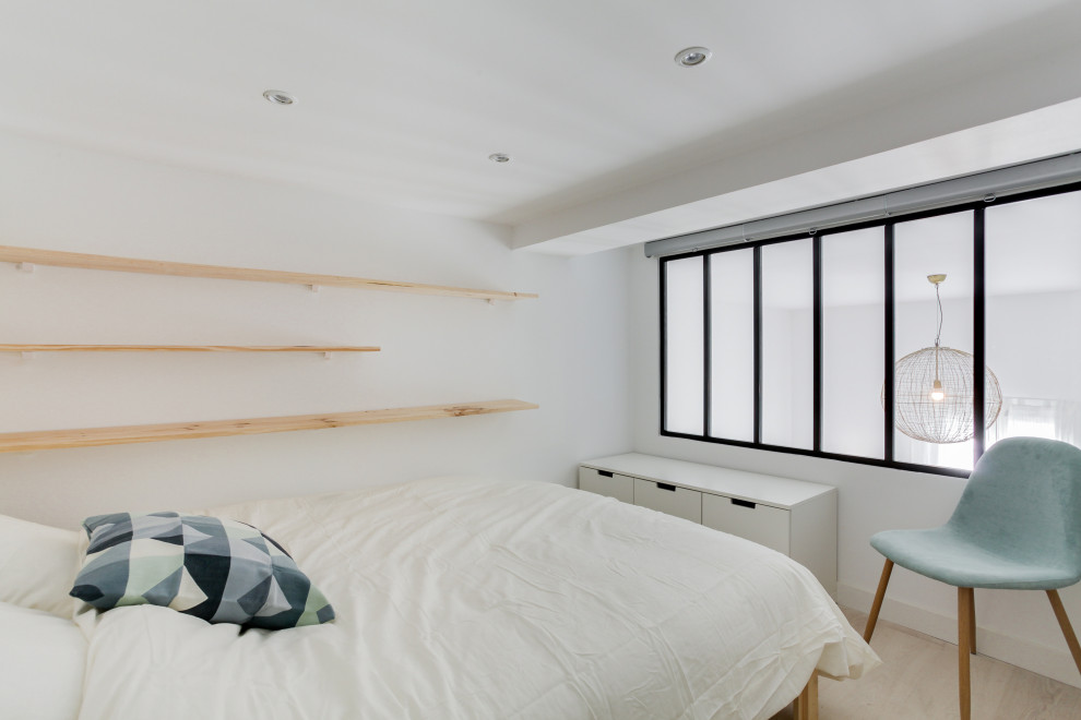Modelo de dormitorio tipo loft escandinavo grande con paredes blancas, suelo de madera clara, suelo marrón y bandeja