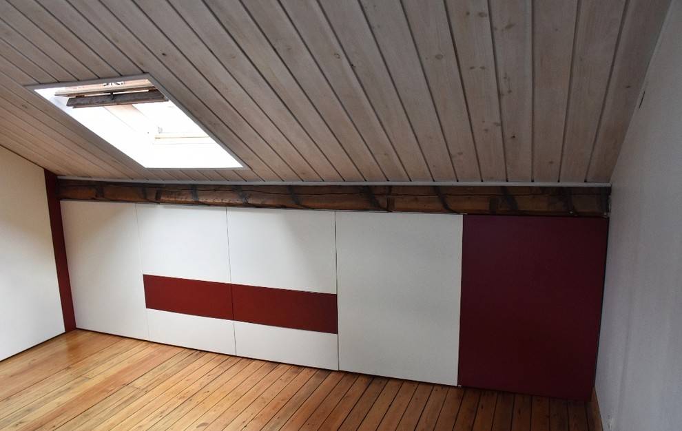 Diseño de dormitorio tipo loft actual grande sin chimenea con suelo de madera clara