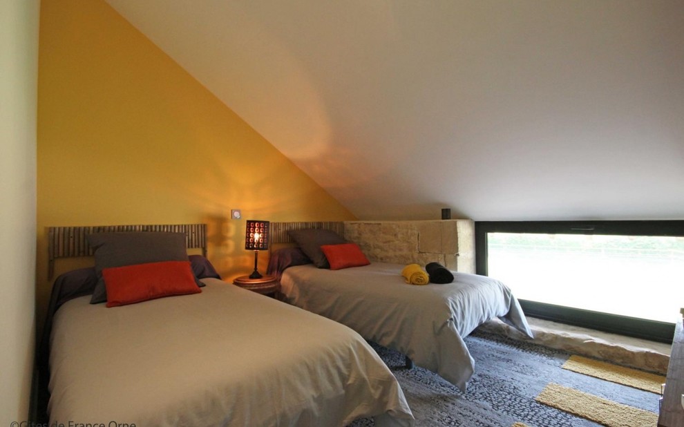 Imagen de dormitorio tipo loft pequeño con paredes amarillas, moqueta y suelo gris