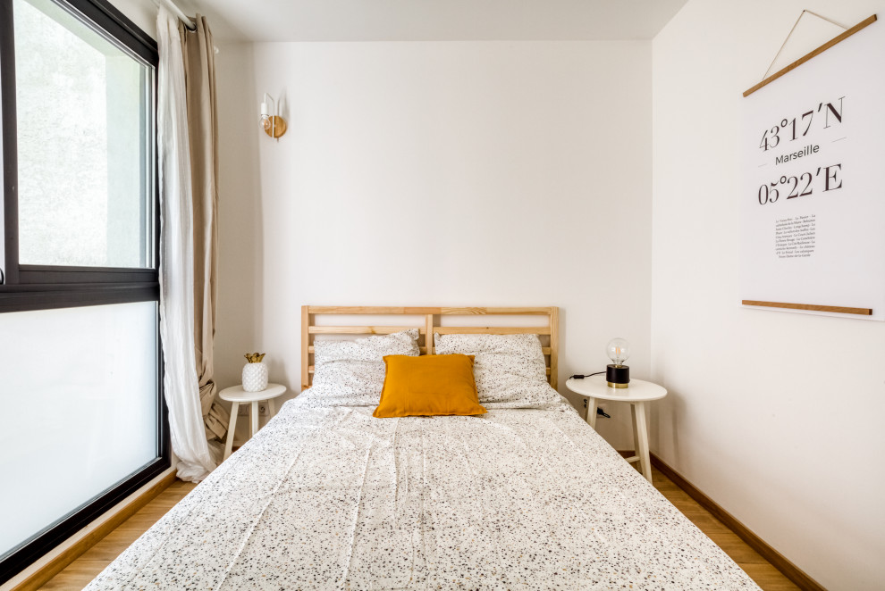 Mittelgroßes Modernes Hauptschlafzimmer mit weißer Wandfarbe, hellem Holzboden, braunem Boden und Holzwänden in Marseille