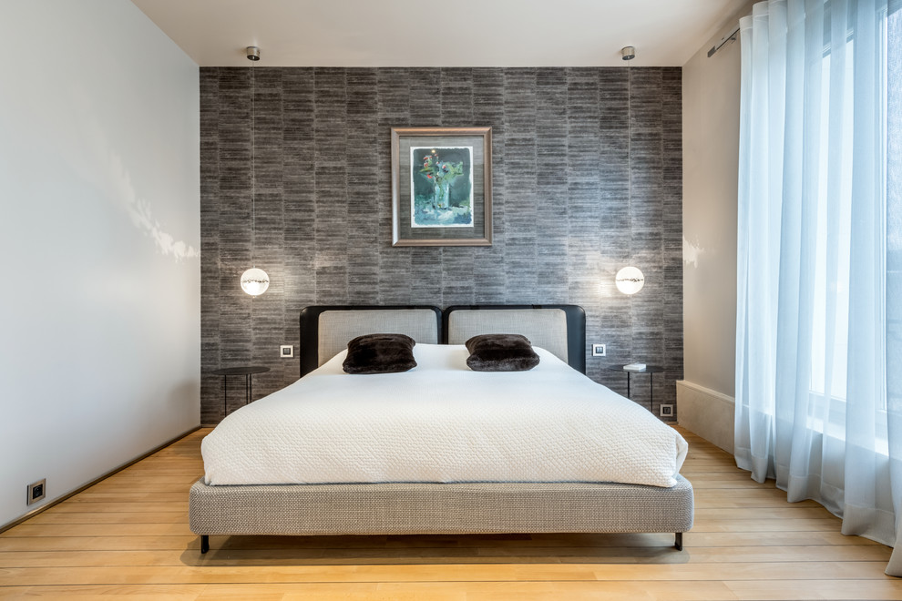Modernes Schlafzimmer mit grauer Wandfarbe, hellem Holzboden und beigem Boden in Lyon