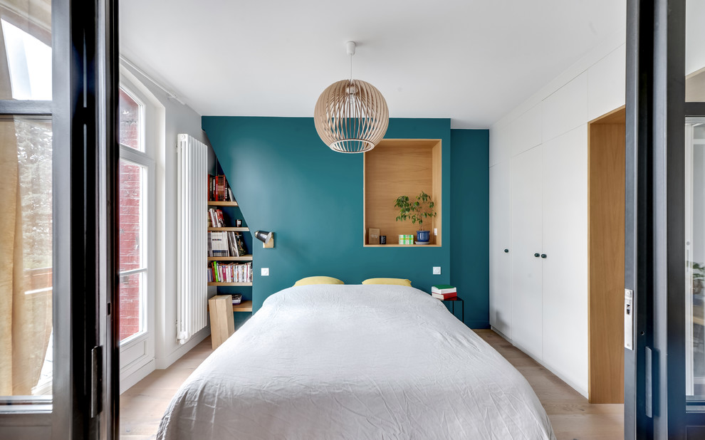 Ejemplo de dormitorio contemporáneo con paredes azules, suelo de madera clara y suelo beige