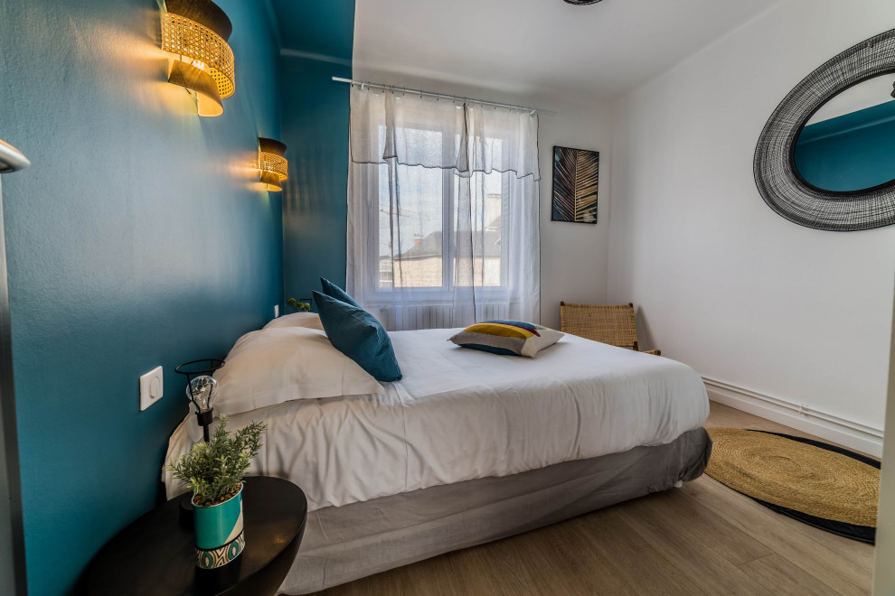 Стильный дизайн: гостевая спальня среднего размера, (комната для гостей) в стиле неоклассика (современная классика) с синими стенами, полом из ламината и коричневым полом без камина - последний тренд