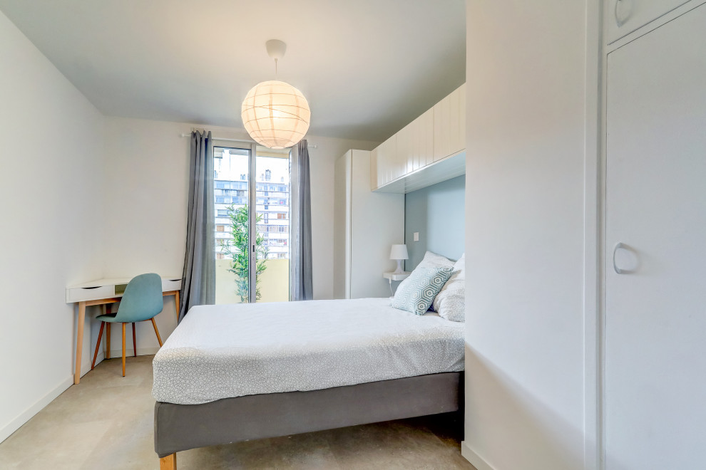 This is an example of a medium sized scandi bedroom in Marseille with blue walls, medium hardwood flooring and beige floors.